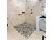 Modern tiled shower with pebble floor, multiple shower heads, and glass door at 13710 Westshire Dr, Tampa, FL 33618