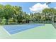 Well-maintained tennis court, surrounded by lush greenery, offers a great recreational space at 13710 Westshire Dr, Tampa, FL 33618