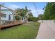 Expansive backyard with pool, wooden deck and dining, lush greenery and white privacy fence at 14030 79Th Ave, Seminole, FL 33776