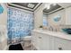 Updated bathroom with white vanity, stylish mirror, and shower with beach themed curtain at 14030 79Th Ave, Seminole, FL 33776