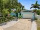 Charming turquoise home featuring a well-manicured lawn, mature trees, and a concrete driveway at 14030 79Th Ave, Seminole, FL 33776