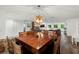Open-concept living area with a modern dining table, views of a fireplace, and an open doorway to the game room at 14030 79Th Ave, Seminole, FL 33776