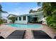 Sparkling pool with a brick paved deck, lounge chairs, lush trees, and outdoor seating area at 14030 79Th Ave, Seminole, FL 33776