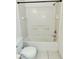 Clean white tiled bathroom features a shower and tub combo with built-in shelves at 14442 Reuter Strasse Cir # 812, Tampa, FL 33613
