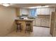 Cozy kitchen features tile floors, an island with seating, and white appliances at 14442 Reuter Strasse Cir # 812, Tampa, FL 33613