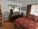 Bedroom with wood floors, a desk area and large window, plus red and gold patterned bedding and curtains at 1448 Temple St, Clearwater, FL 33756