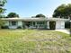 Charming single-story home with a well-maintained lawn, mature trees, and inviting curb appeal at 1448 Temple St, Clearwater, FL 33756