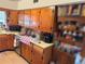 Kitchen features wooden cabinets with silver hardware, stainless steel appliances, and tile flooring at 1448 Temple St, Clearwater, FL 33756