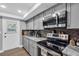 This remodeled kitchen features stainless steel appliances, gray cabinets and subway tile backsplash at 1485 Lakeview Rd # 2, Clearwater, FL 33756