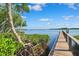 Picturesque waterfront view from a wooden dock surrounded by lush greenery and a clear blue sky at 1531 75Th Ne Cir, St Petersburg, FL 33702