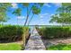 Scenic wooden dock surrounded by lush greenery, leading to calm waters under a clear blue sky, with a tranquil view at 1531 75Th Ne Cir, St Petersburg, FL 33702