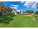 Beautiful backyard with a lush green lawn leading up to a waterfront property with a metal roof and beautiful landscaping at 1531 75Th Ne Cir, St Petersburg, FL 33702