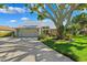 Charming home featuring a lush landscaped front yard, driveway, and a large shade tree at 1531 75Th Ne Cir, St Petersburg, FL 33702