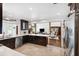 Modern open kitchen with white counters, tile floors, and dark wood cabinets provides a clean and functional cooking space at 1531 75Th Ne Cir, St Petersburg, FL 33702