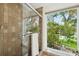 Shower featuring glass door and a view of lush landscaping at 1531 75Th Ne Cir, St Petersburg, FL 33702