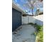 View of a fenced backyard with concrete slab with lush greenery and a gate for access at 15416 2Nd E St, Madeira Beach, FL 33708