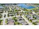Expansive aerial view of a residential area with homes, a large lake, and a playground in a central park at 1669 Feather Grass Loop, Lutz, FL 33558