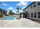 Beautiful backyard featuring a sparkling pool, paved patio, and outdoor seating area with an elegant pergola at 1669 Feather Grass Loop, Lutz, FL 33558