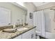 Bathroom featuring granite countertops, a mirror, and shower with tile surround at 1669 Feather Grass Loop, Lutz, FL 33558