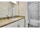 Well-lit bathroom featuring a granite countertop, tiled shower, and neutral color palette at 1669 Feather Grass Loop, Lutz, FL 33558