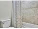 Clean bathroom featuring a tub with stylish shower curtain and tiled walls at 1669 Feather Grass Loop, Lutz, FL 33558