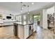 Open concept kitchen island with seating that looks out to the living room and outdoor dining space at 1669 Feather Grass Loop, Lutz, FL 33558