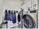 Well-equipped laundry room with modern washer, dryer and ample storage space at 1669 Feather Grass Loop, Lutz, FL 33558