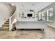 Bright living room with tray ceiling, built-in cabinets, and wood-look tile floor at 1669 Feather Grass Loop, Lutz, FL 33558