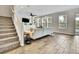 Bright living room boasts large windows, tile floors, and a modern entertainment center, perfect for Gathering gatherings at 1669 Feather Grass Loop, Lutz, FL 33558