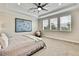 Serene primary bedroom featuring a decorative ceiling fan, and abundant natural light, creating a peaceful retreat at 1669 Feather Grass Loop, Lutz, FL 33558