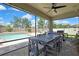 Spacious screened-in patio features an outdoor dining area, ceiling fan, and swimming pool view at 1669 Feather Grass Loop, Lutz, FL 33558