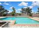 A pristine in-ground pool surrounded by manicured landscaping, with stone pavers and privacy fencing at 1669 Feather Grass Loop, Lutz, FL 33558
