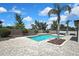 In-ground pool with a patio, stone accents, mature trees, and landscaping, ideal for outdoor fun at 1669 Feather Grass Loop, Lutz, FL 33558