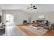 Staged living room featuring a ceiling fan, wood floors and access to the patio at 1706 Erin Brooke Dr, Valrico, FL 33594