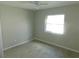 An empty bedroom featuring a ceiling fan and light-filled window, complemented by modern vinyl flooring at 2114 Intervista Ln, Valrico, FL 33594