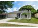 Charming single-story home featuring a well-manicured lawn, palm trees, and attached garage at 2114 Intervista Ln, Valrico, FL 33594