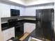 Well-lit kitchen with white cabinetry, black appliances, and modern countertops at 2114 Intervista Ln, Valrico, FL 33594
