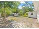 Backyard featuring perimeter fencing, mature trees and lush greenery, with an outbuilding for storage at 2320 Harn Blvd, Clearwater, FL 33764