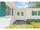 Charming front entrance featuring double glass doors, brick accents, and lush green landscaping at 2320 Harn Blvd, Clearwater, FL 33764