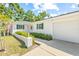 White brick home features green shutters, a well-maintained lawn, and a spacious two-car garage at 2320 Harn Blvd, Clearwater, FL 33764