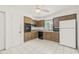Well-lit kitchen with white tiled floors, wood cabinets, and a white refrigerator at 2320 Harn Blvd, Clearwater, FL 33764