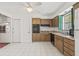 Bright kitchen featuring white tile flooring, wooden cabinets, and black appliances at 2320 Harn Blvd, Clearwater, FL 33764