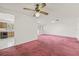Open living room with reddish carpet next to a kitchen with wood cabinets at 2320 Harn Blvd, Clearwater, FL 33764