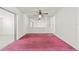 Bright living room featuring a mirrored wall, ceiling fan, and reddish carpet at 2320 Harn Blvd, Clearwater, FL 33764