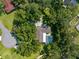Aerial view of a house surrounded by verdant trees features a screened pool and a tranquil backyard setting at 23327 Christian Cir, Brooksville, FL 34601