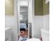 Bathroom featuring wainscotting and an arched doorway leading to bedroom with terra cotta tile at 23327 Christian Cir, Brooksville, FL 34601