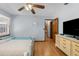 Bright bedroom featuring wood floors, natural light, and dresser with a television at 23327 Christian Cir, Brooksville, FL 34601