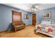 Cozy bedroom with natural light, ceiling fan, and a comfortable sitting area for relaxation at 23327 Christian Cir, Brooksville, FL 34601