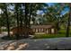 Charming single-story brick home with lush landscaping, mature trees, and a welcoming front porch at 23327 Christian Cir, Brooksville, FL 34601
