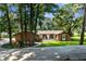 Charming single-story brick home with lush landscaping, mature trees, and a welcoming front porch at 23327 Christian Cir, Brooksville, FL 34601
